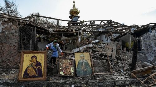 Komyshuvakha, Ukraine. A woman collects icons at the site of a church destroyed by a missile strike
